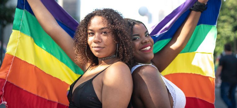 two women with the Pride flag