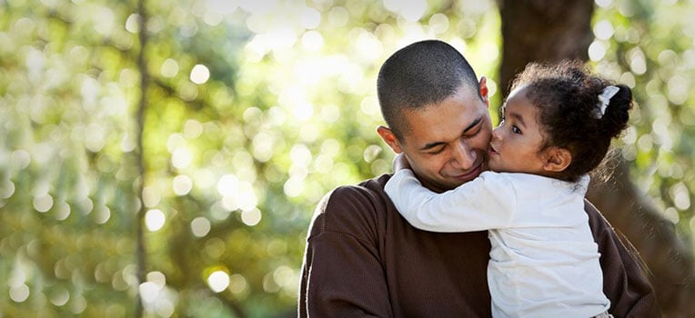father holding his daughter up in a hug