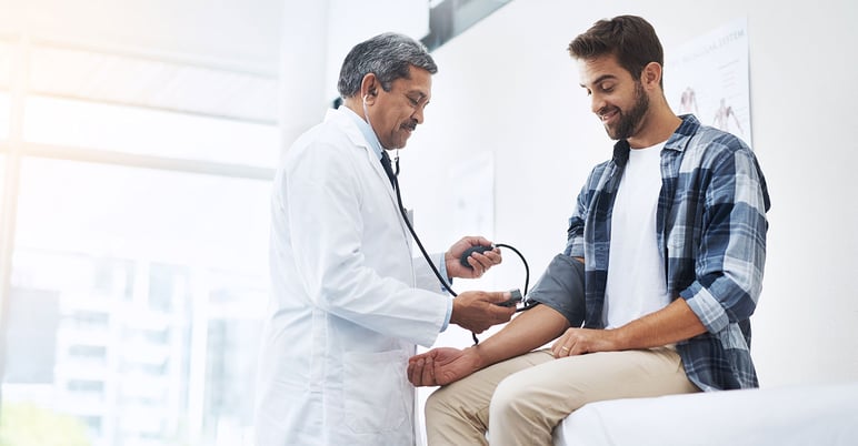 medical provider measuring his male patient's blood pressure