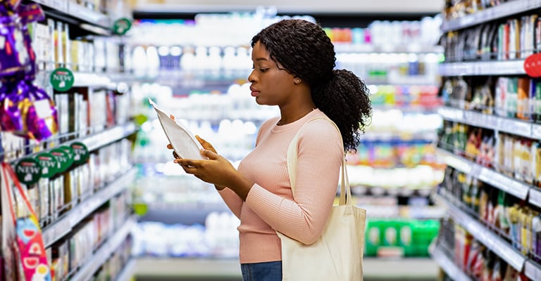 woman in the supermarket reading nutrition facts