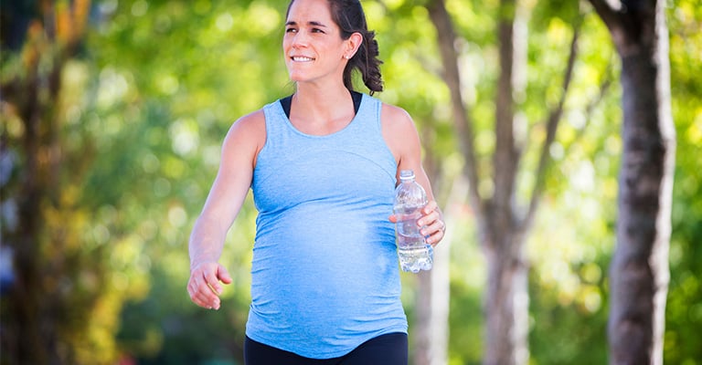 pregnant woman strolling quickly in the park for exercise