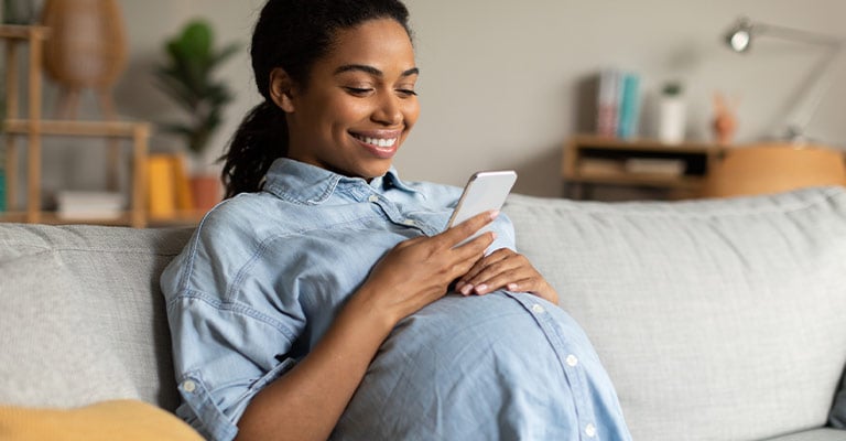 seated pregnant woman looking at her phone
