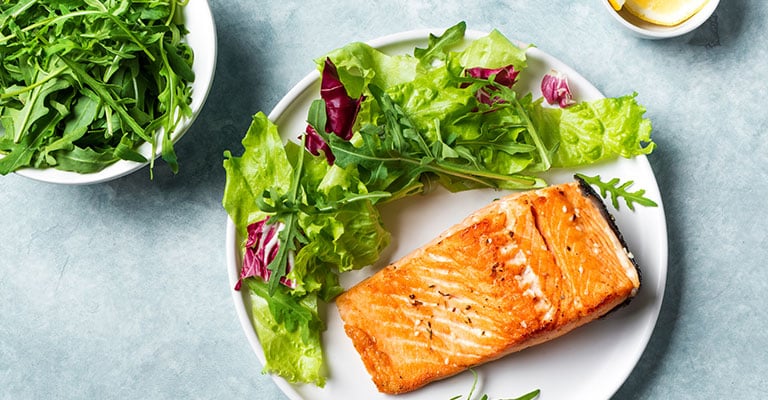 salmon and salad on a white plate
