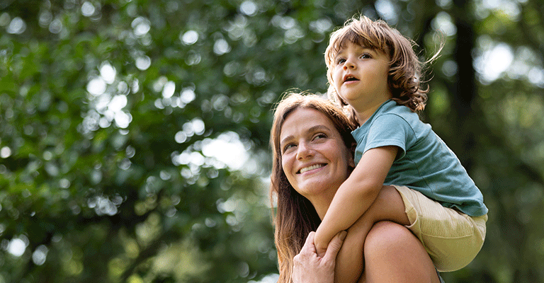 woman holding her child on her shoulders