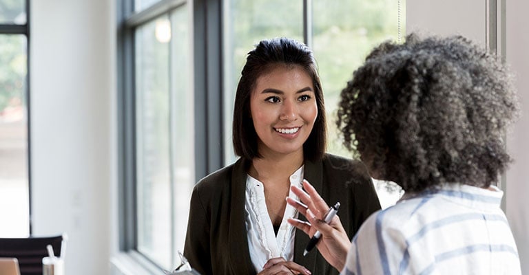 two colleagues chatting in workplace