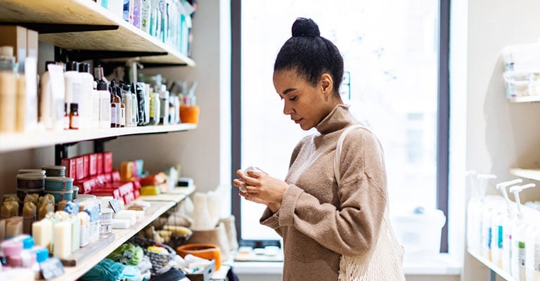 woman evaluating products on a shelf
