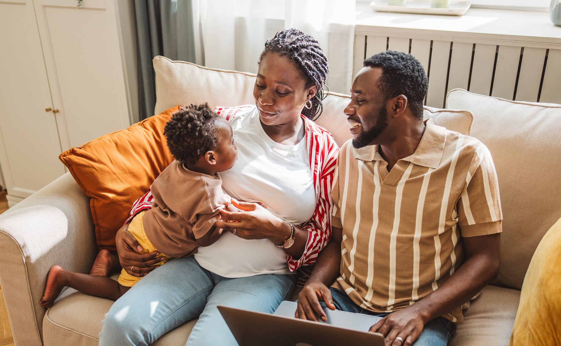 family-of-three-with-toddler-relaxing-on-couch