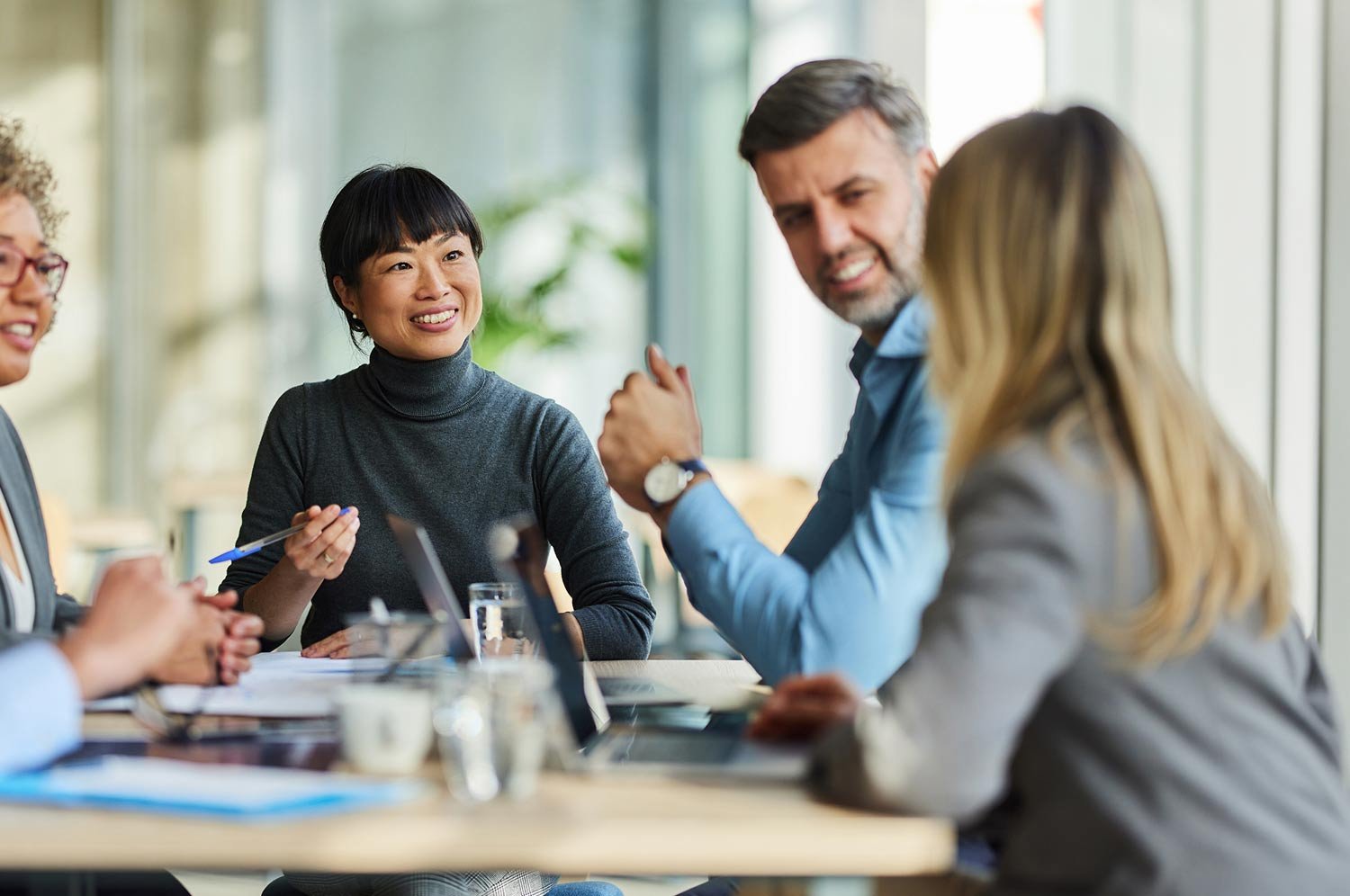 group-of-happy-colleagues-at-conference-room-table-1500px