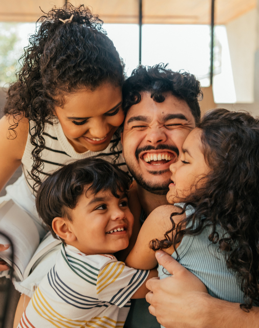 happy family with 2 kids hugging
