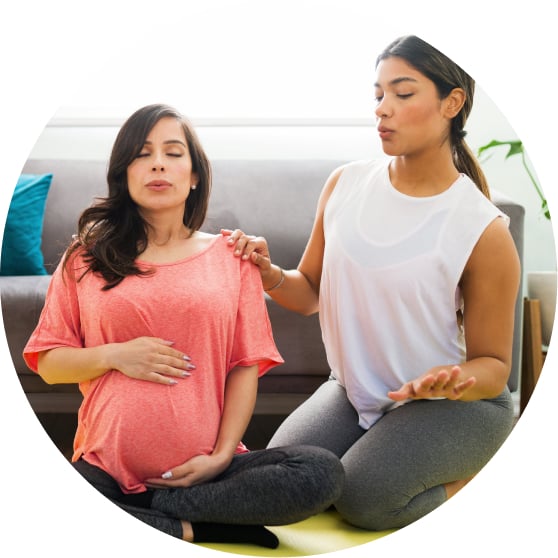 pregnant woman with doula practicing breathing exercises