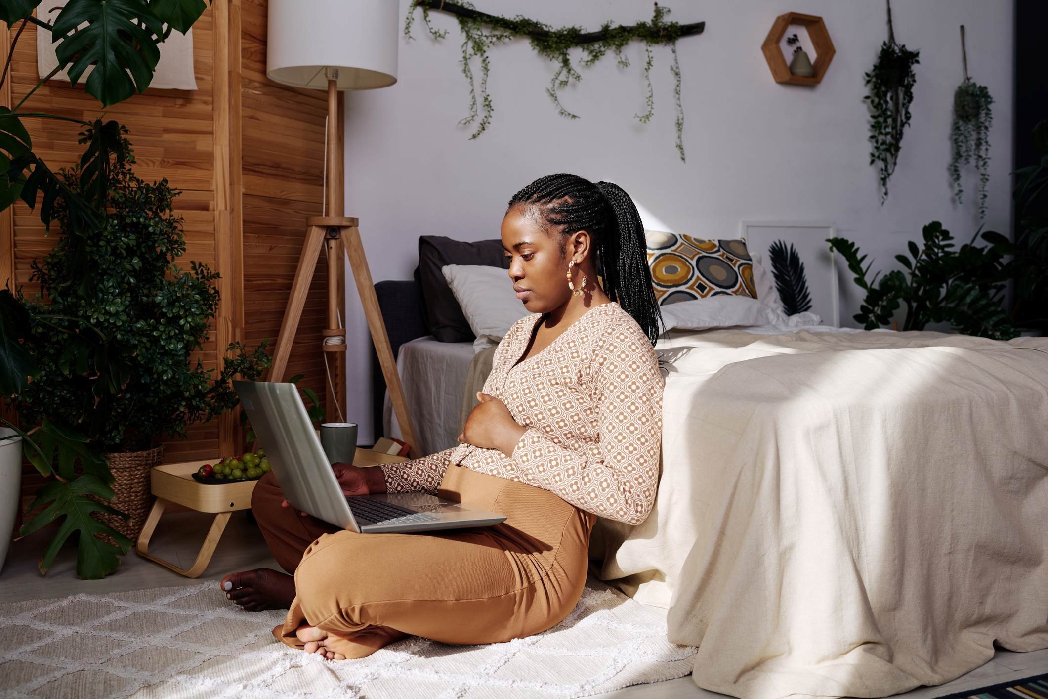 pregnant-woman-cradling-belly-while-seated-on-the-floor