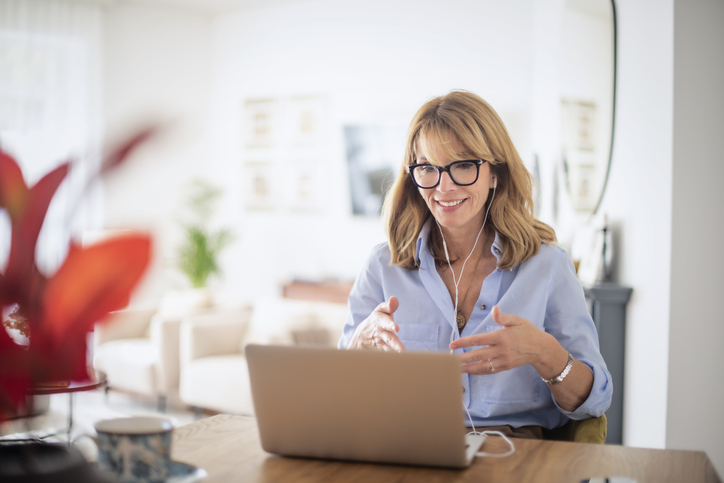 woman in midlife looking enthusiastically at her laptop