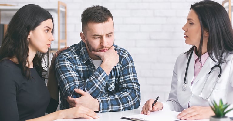 man with his partner, thinking about what the provider is saying
