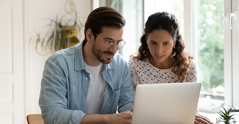 a pair researching fertility clinics on laptop