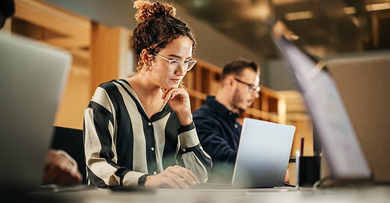 woman focusing on working on her laptop in the office