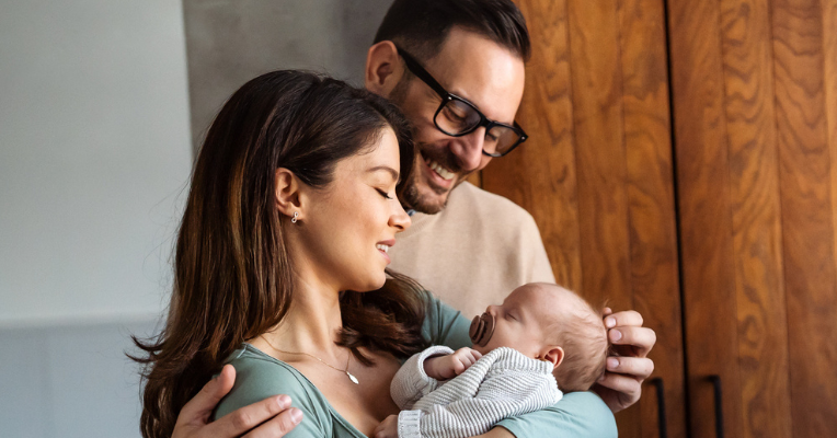 two parents holding their newborn