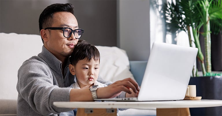 father helping his son typing on the laptop