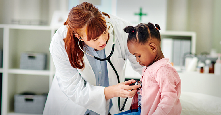 doctor hearing the heartbeat of young child