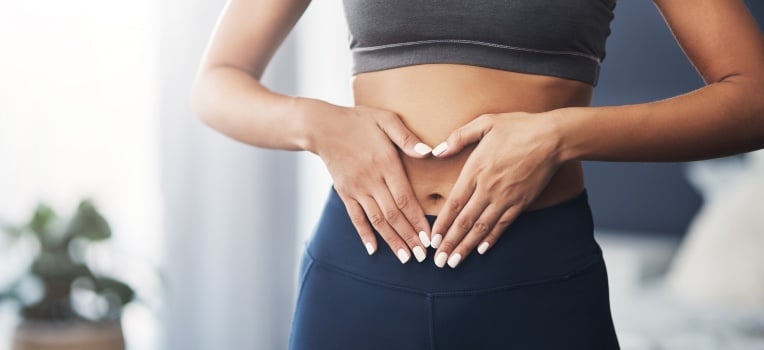 hands in the shape of a heart over stomach