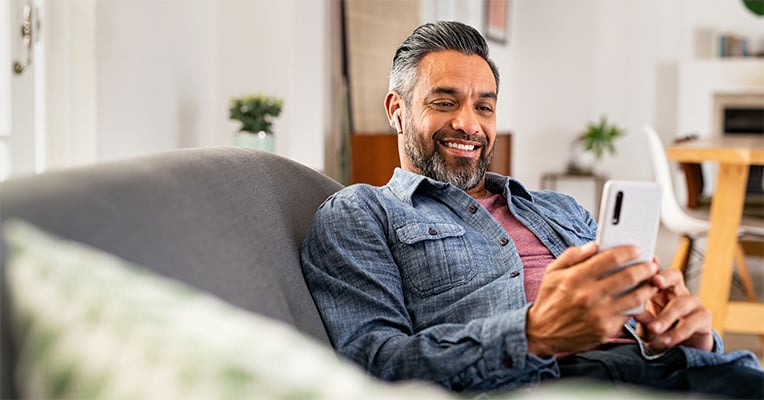 man on the couch looking at his phone