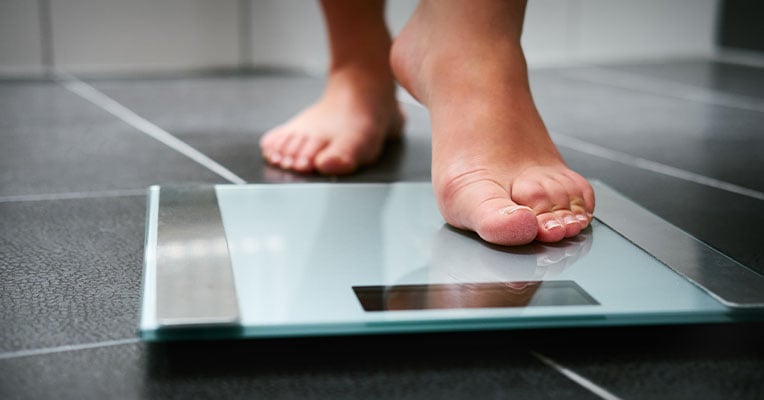 foot stepping onto a scale