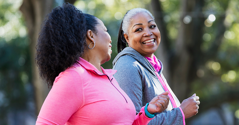 two women in middle age speed walking at the park