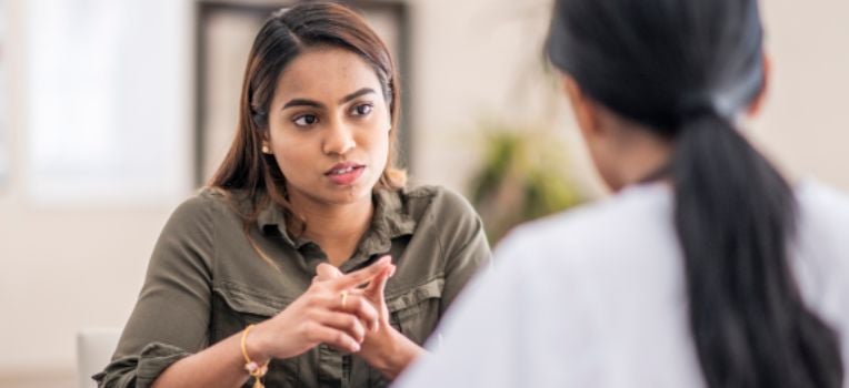 woman gesturing with her hands to explain something to her friend