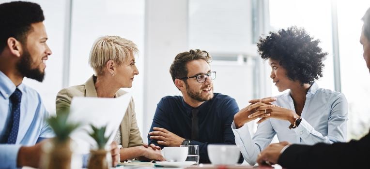 group of seated colleagues chatting at work