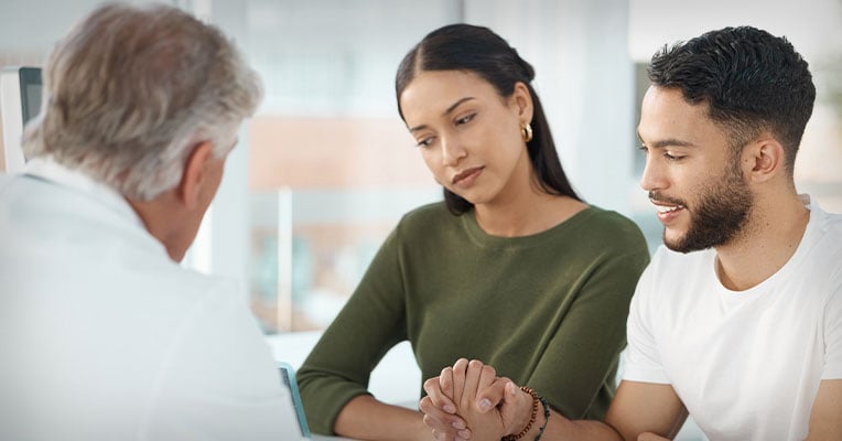 couple listening to their provider at the doctor's office