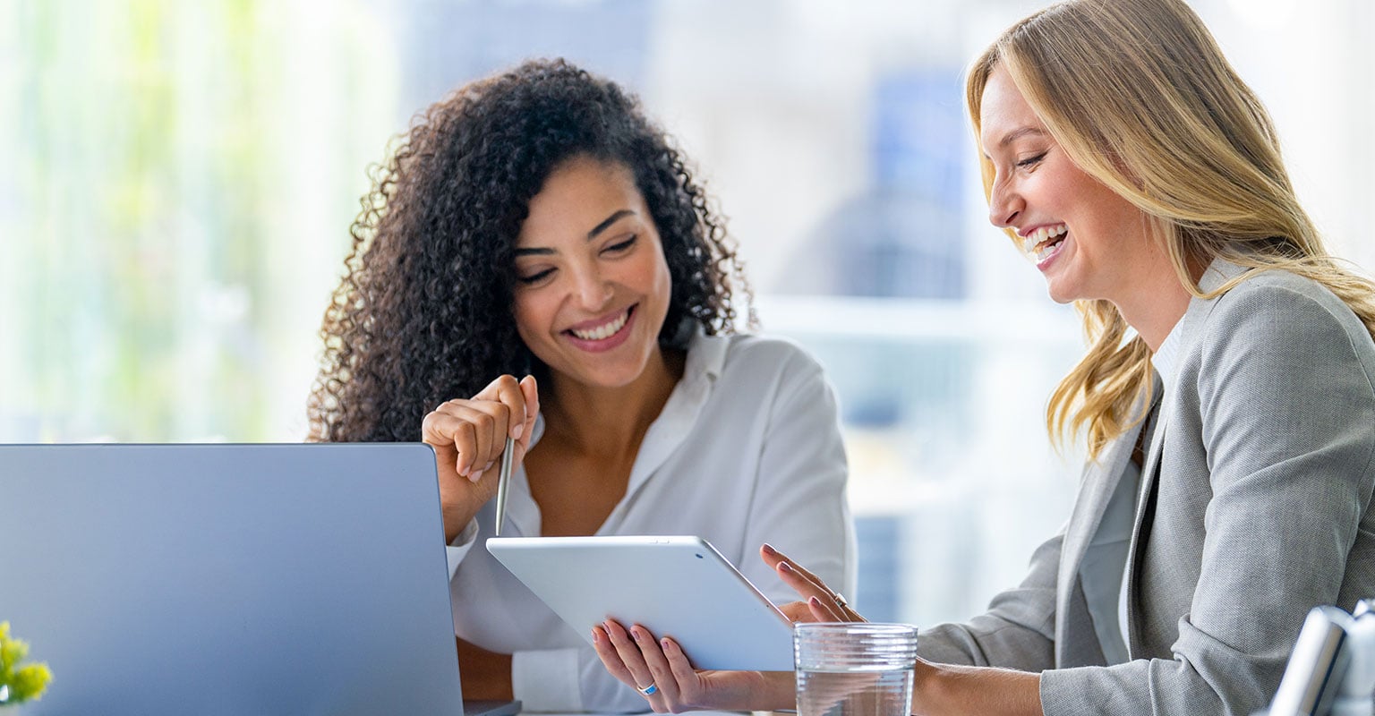 smiling woman looking at ipad