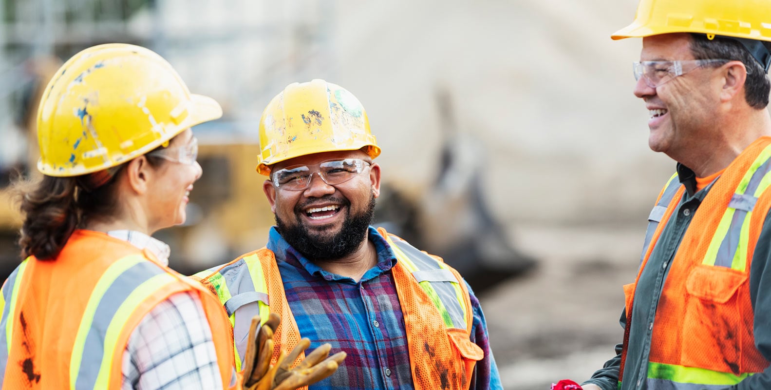 colleagues in hard hats at a construction site