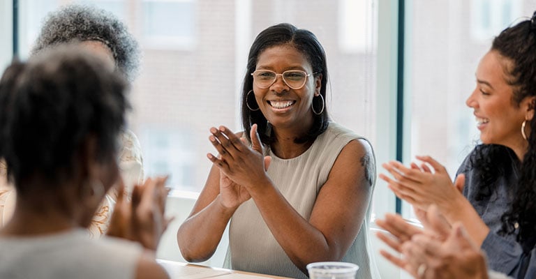 women clapping at work upon receiving menopause benefits