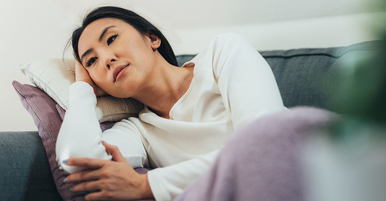 woman laying on her couch after egg retrieval