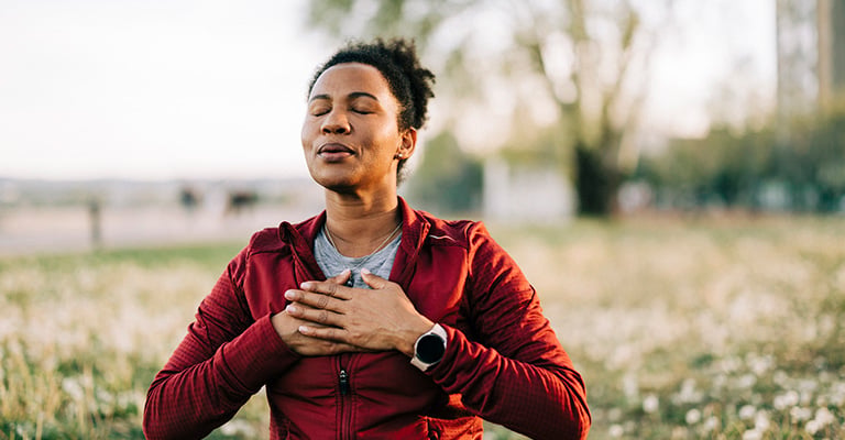 woman breathing deeply with hands on heart