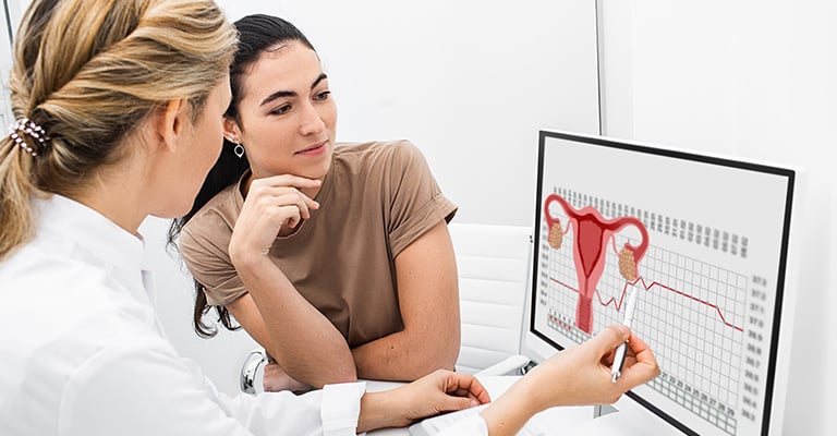 two women looking at the diagram of a female reproductive system