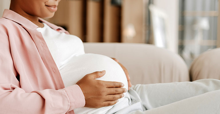 cropped image of pregnant woman seated on couch