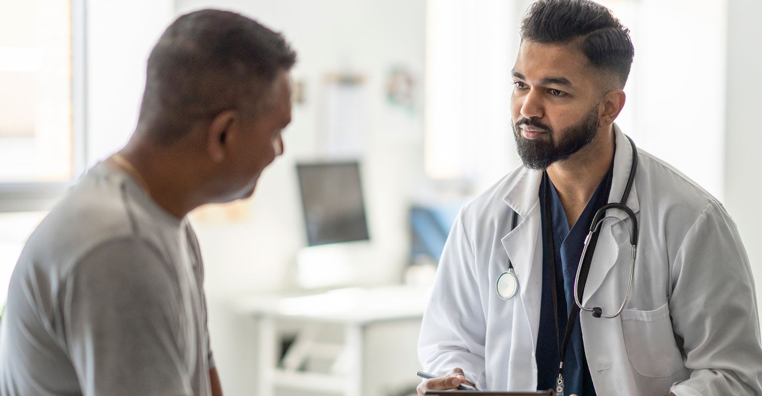 male doctor listening to male patient