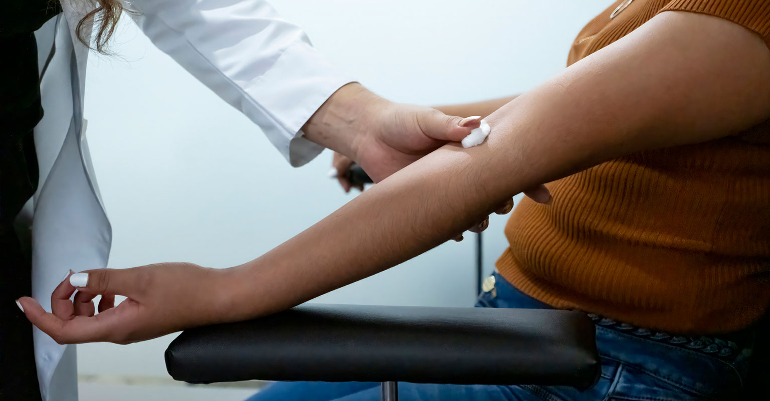 provider holding gauze on someone's arm after a blood test