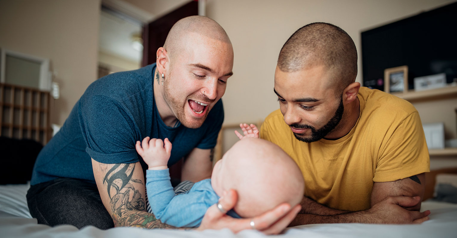 same-sex male couple playing with their baby
