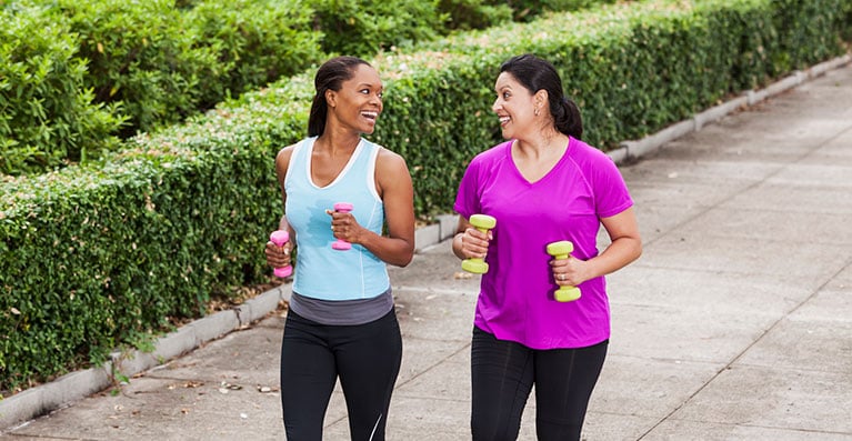 two women jogging with light weights in hand