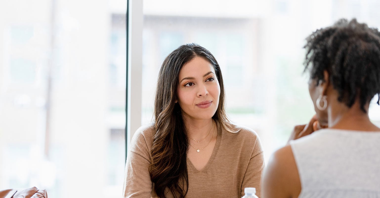 two women seated facing each other in discussion