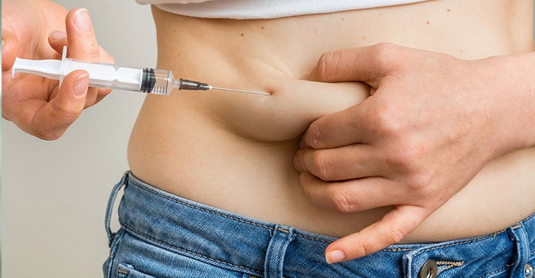 woman injecting fertility medication into her stomach