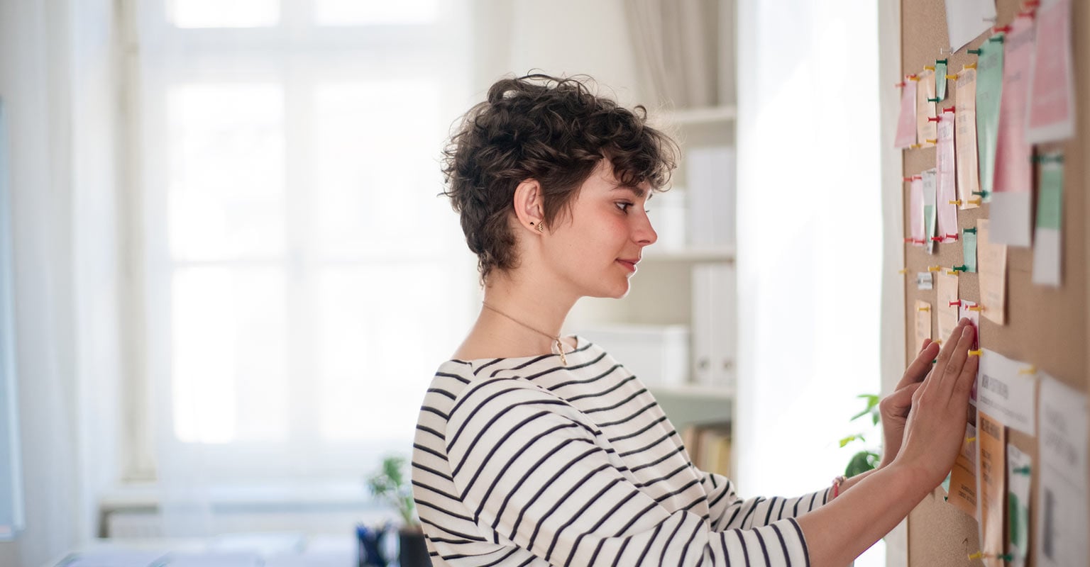 woman pinning something on a bulletin board
