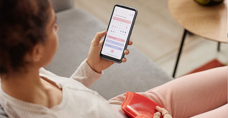 woman looking at an ovulation tracking app on her phone