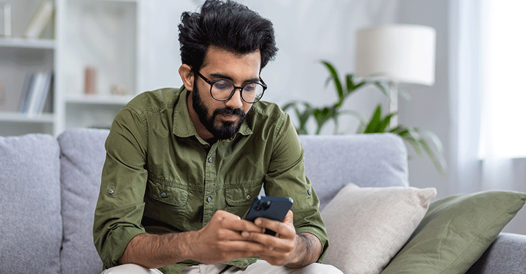seated man scrolling on phone