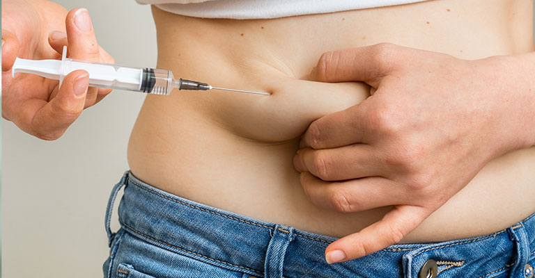 woman with syringe injecting her side