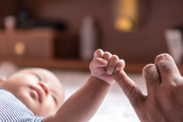 baby holding parent's finger