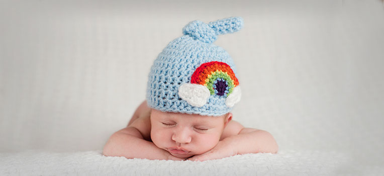 newborn baby wearing knitted rainbow hat