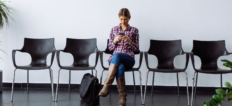 photo of woman in waiting room, on her phone