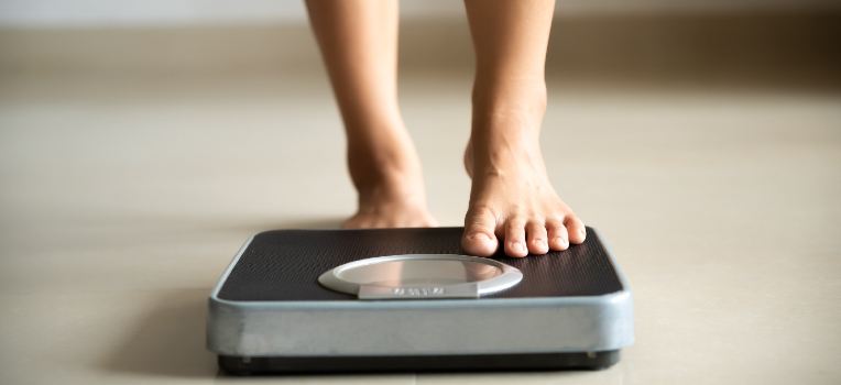 focused photo of feet stepping onto scale